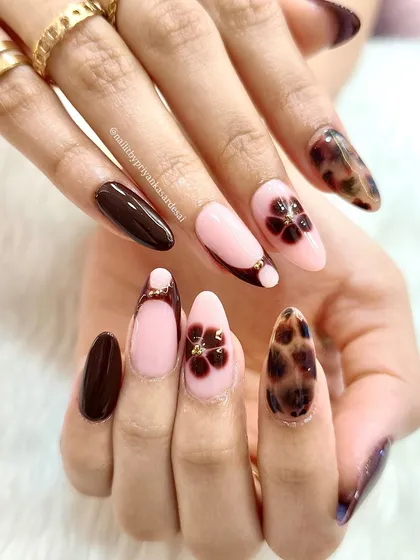 Flower power meets fierce print. This sweet-meets-sassy manicure combines a dark tortoiseshell print with soft pink nails and delicate floral accents.