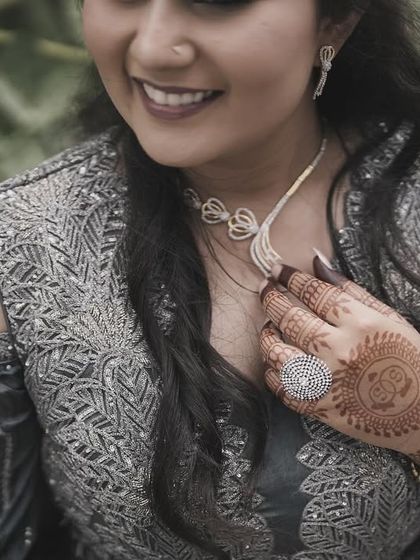 A close-up showing the delicate necklace and the intricate details of her henna.
