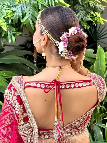 A detailed shot of a floral bun, showing the careful arrangement of fresh flowers. This hairstyle is a beautiful way to incorporate natural elements into your bridal look.