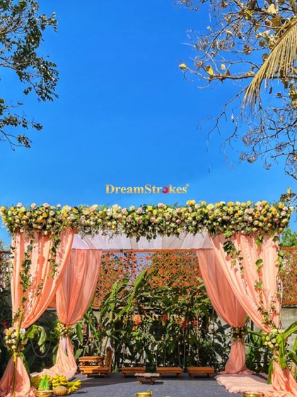 A full view of the sunny, open-air mandap, showing how the floral arrangements and drapes create a festive and sacred space for the wedding ceremony.