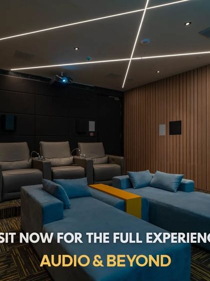 A look inside one of our showroom's demonstration theaters. This space combines modern aesthetics with high-performance technology, featuring wood-paneled acoustic walls, recessed ceiling speakers for Dolby Atmos, and a mix of sofa and recliner seating.