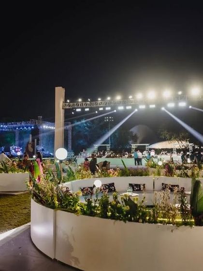 The guest seating area is just as important as the main stage. Here, we designed curved, modern white lounge seating within planters to create an elegant and comfortable space for guests near the entrance.