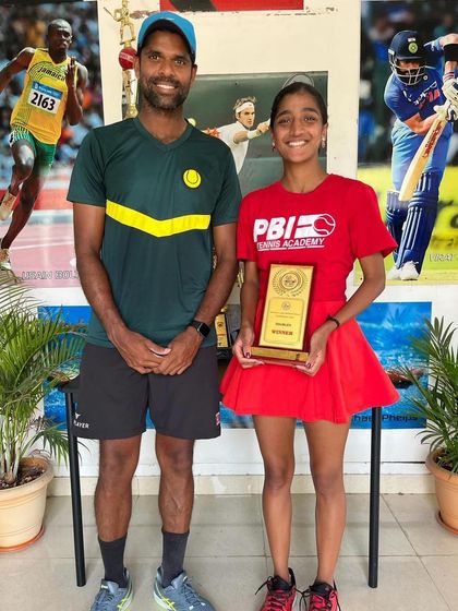 A champion and her coach. This photo highlights the crucial relationship between player and coach in achieving success, celebrating a hard-earned AITA title.