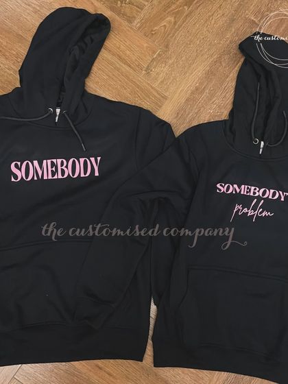 A playful take on couple's apparel, these matching black hoodies read "Somebody" and "Somebody's Problem." It's a fun and cheeky gift for couples who share a great sense of humor.