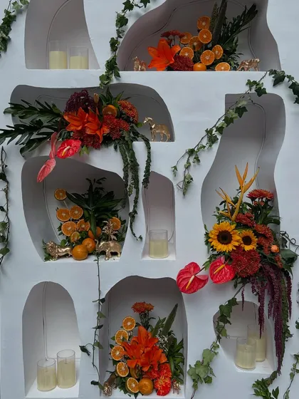 A detailed look at the custom-built wall with niches, each styled with unique floral arrangements, citrus fruits, and golden animal figures.