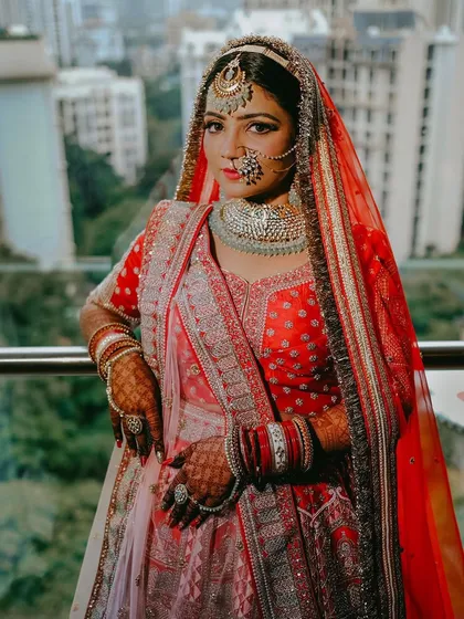A powerful portrait of the bride in her red lehenga, showcasing her confidence and the regal quality of her complete look.