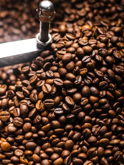 A close-up of coffee beans in a roaster. This kind of detailed, textural shot is great for brands that want to tell the story of their process.