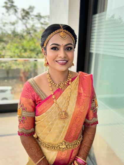 A full shot of this beautiful bride. The makeup is perfectly balanced with her elegant saree and traditional jewellery.