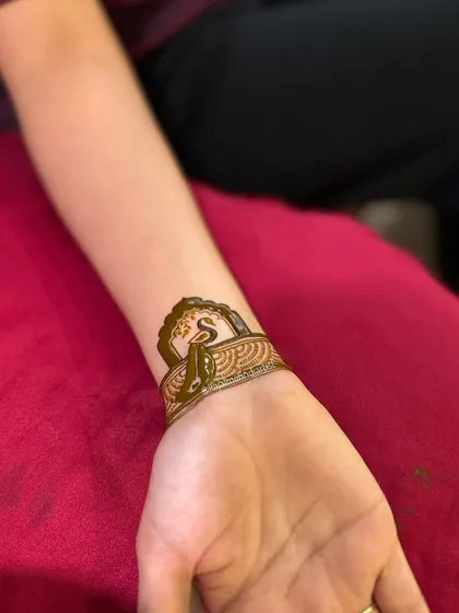 A view of the completed wristband with the initial. The dark henna paste promises a beautiful, rich stain.