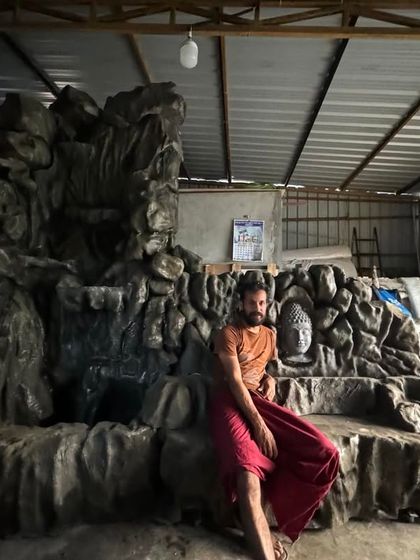 Taking a moment to rest next to a large, custom waterfall sculpture in our workshop. These pieces require a lot of time and effort.