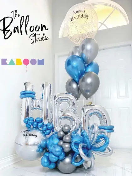A grand "HBD" balloon sculpture in silver and blue. This large-scale arrangement makes a huge impact and serves as a fantastic photo backdrop for the birthday boy.