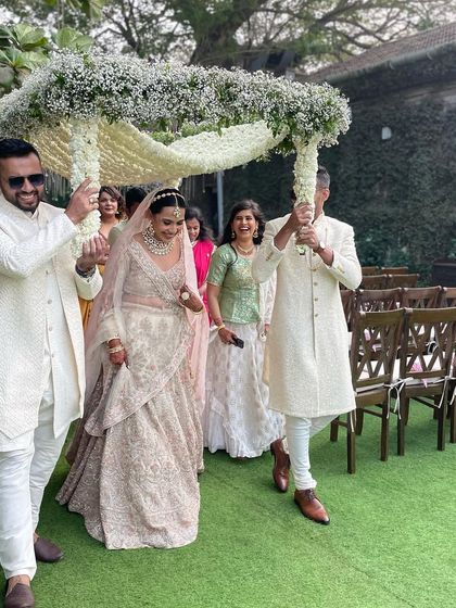 A close-up of the bride's entry under a canopy of baby's breath. This delicate and elegant floral chadar is one of our favorite ways to make the bridal procession truly special.