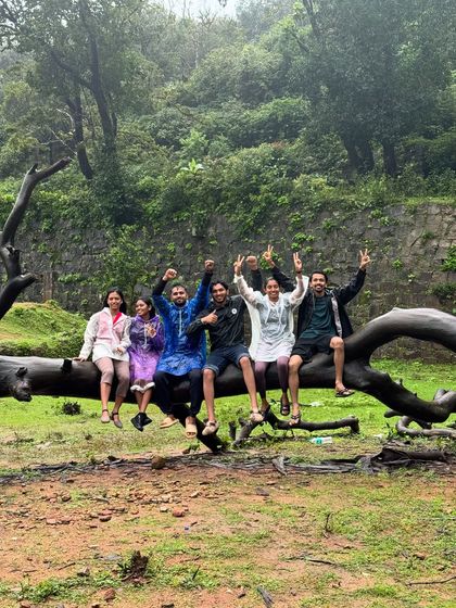 A fun group photo on a fallen tree log near Hidlumane Falls. The journey is filled with these playful moments.