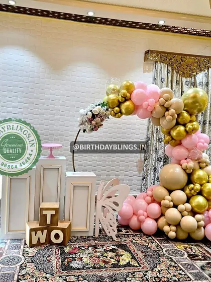 A beautiful balloon arrangement for a second birthday, using a sophisticated palette of nude, pink, and gold. The wooden "TWO" blocks are a charming detail.