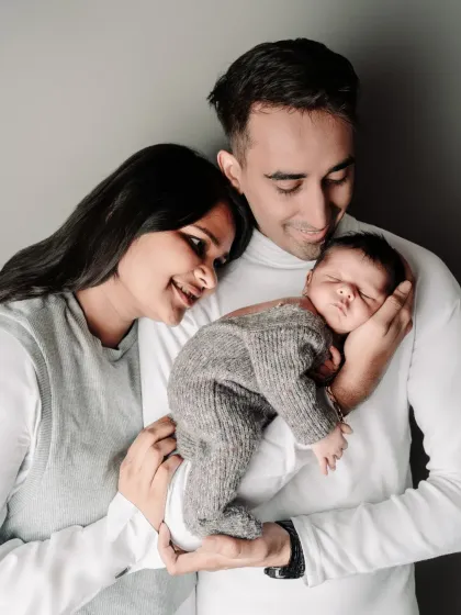 A classic studio portrait of new parents cradling their newborn. These are the timeless, frame-worthy photos that become family heirlooms, showing the beginning of your new life together.