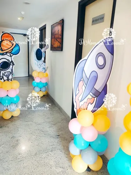 The space adventure continues down the hallway with themed cutouts of astronauts and rockets on colorful balloon pillars.