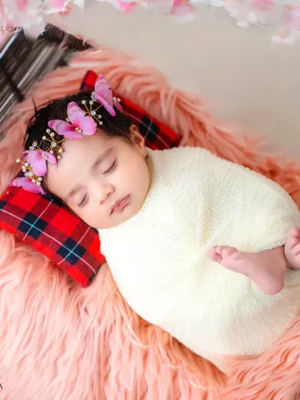 The peaceful, angelic sleep of a newborn baby, swaddled snugly and adorned with a delicate butterfly headband. I handle these precious first-day shoots with the utmost care and gentleness.
