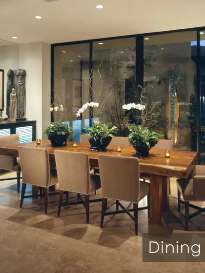 This spacious dining room is designed for large gatherings, featuring a solid wood table and floor-to-ceiling windows that bring in natural light. The side bar cabinet adds functionality for serving and storage.