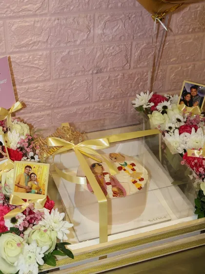 A sweet celebration of love. This beautiful anniversary gift set features a personalized portrait cake, flowers, and photos of the happy couple.