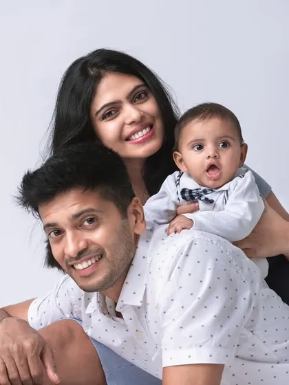 Playful moments often make the best portraits. Here, the baby enjoys a fun piggyback ride on dad, resulting in genuine smiles from everyone. This is a great example of a relaxed and happy family studio session.