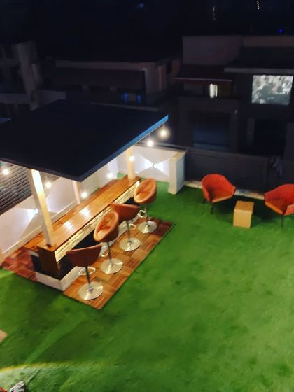 An aerial view of the rooftop bar and lounge area at night, showing the layout and the warm, inviting glow of the lights.