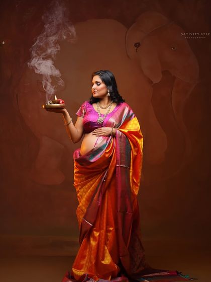 A spiritual and serene portrait, with the mother-to-be holding a diya. The bare baby bump is a beautiful focal point, celebrating the life within.