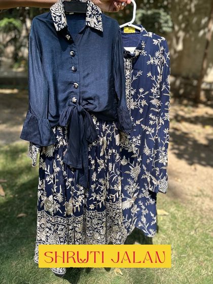 For a sophisticated sibling look, I created this navy blue set with intricate white floral prints. The girl's outfit features a tie-front shirt and skirt, while the boy's is a classic collared kurta, perfect for family events.