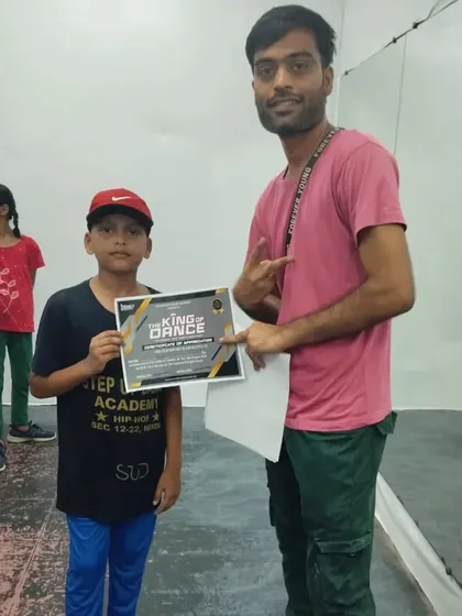 A student proudly holding his competition prize. This certificate is proof of his dedication in our hip-hop training batch.