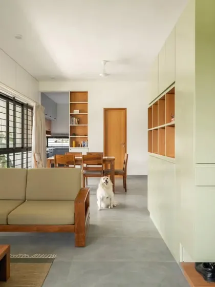 An open-plan living and dining area in the DUBEY Home. This view highlights the fluid layout, the use of warm wood tones against a neutral palette, and our consideration for all family members, including pets, in the spatial design.