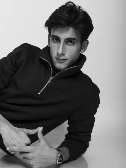A cool and casual black and white portrait of a male model. The pose is relaxed but confident.