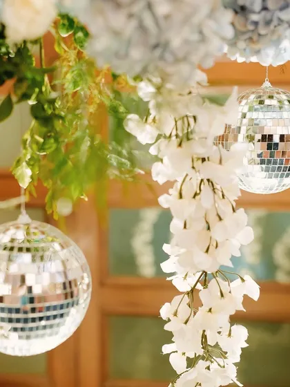 A close-up of the Sangeet decor, where we mixed the old-school charm of disco balls with delicate white floral strings and blue hydrangeas. This combination of shimmer and softness created a unique and glamorous look.