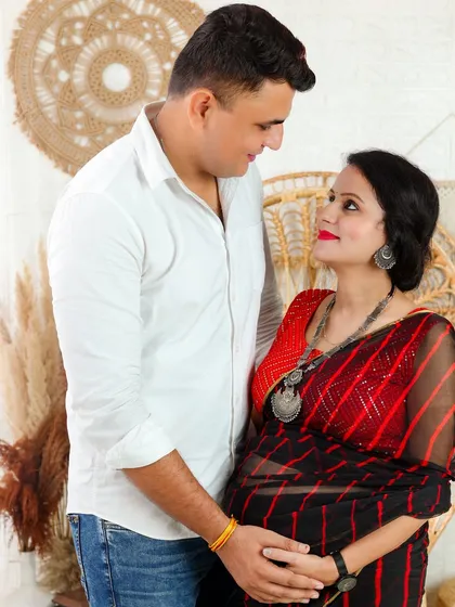 I welcome diverse cultural styles in my sessions. This expecting mother looks radiant in a beautiful red and black saree, adding a touch of traditional elegance to her maternity portrait with her partner.