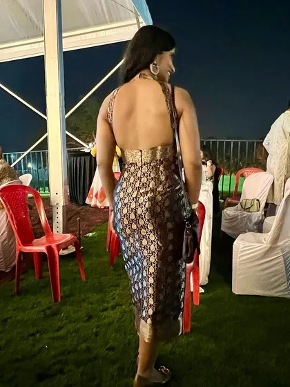 The back view of a client's custom Benaras fabric dress, showing off the halter-neck and backless design that blends tradition with a western silhouette.