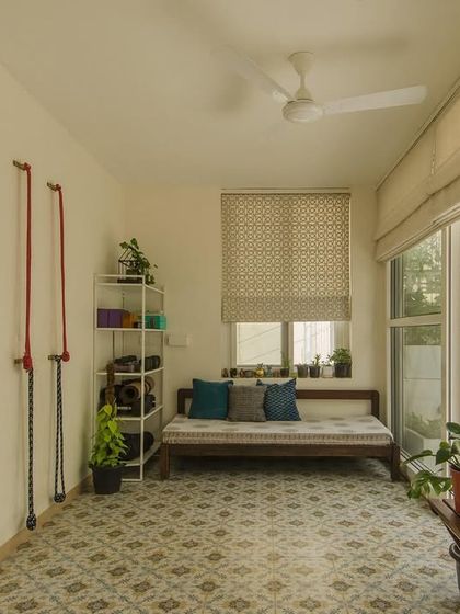 The terrace room, designed for various moods and activities. The yellow louvered door adds a playful touch, while the patterned floor tiles and comfortable daybed make it a favorite spot in the house.