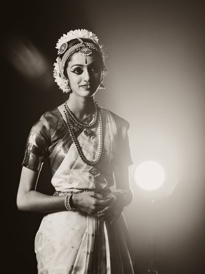 An elegant, softly lit portrait of a Bharatanatyam dancer. The sepia tone adds a timeless, classic feel to this artistic performance shot.