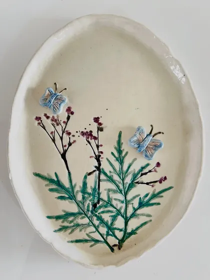 This beautiful oval platter is decorated with hand-painted branches and tiny 3D butterflies, a piece from a student's nature-inspired collection.
