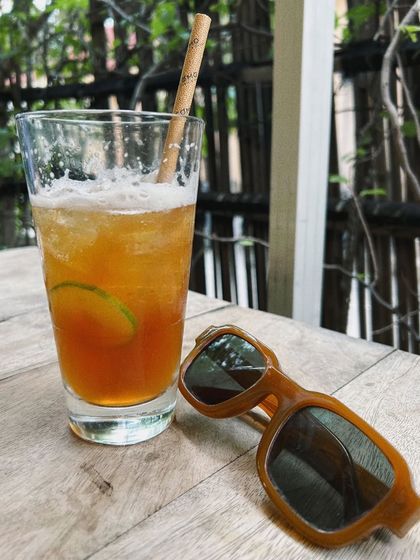 A throwback to brunch in 2022. A simple shot of a refreshing drink and sunglasses can evoke a whole mood of relaxation and leisure.