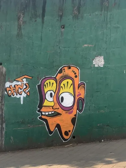 A quick character I painted on a green wall. This trippy, wide-eyed face is a recurring theme in my work, exploring a more psychedelic and abstract style.