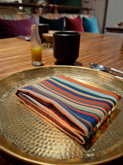The colorful striped napkin and brass plate that begin the dining experience at Loya.