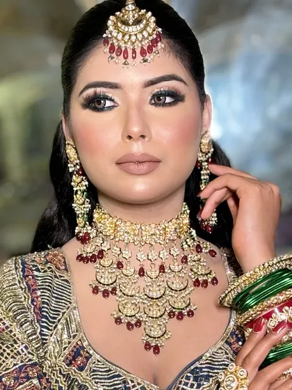 A full portrait of the blue eyeshadow look, showing how it ties together with the intricate, multi-colored lehenga.