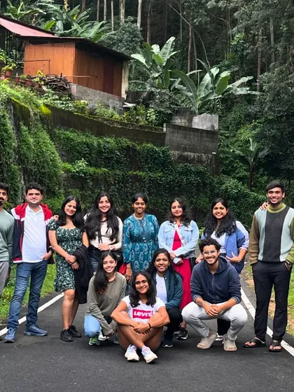 A group photo on a quiet road surrounded by lush greenery.