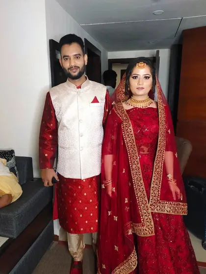 Here is another couple I styled. The groom is wearing a red kurta with a white Nehru jacket, and his clean makeup look matches the bride's beautiful red lehenga.