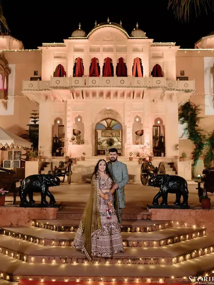 A classic portrait of Sanyukta and Sannidhya at Rambagh Palace, with the candle-lit steps creating a warm and inviting ambiance.