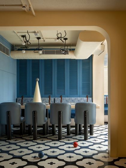 A view into the blue dining zone at Masala, framed by a soft, arched doorway. The custom floor tiles and unique chair design demonstrate our focus on creating a cohesive and memorable spatial identity through bespoke details.
