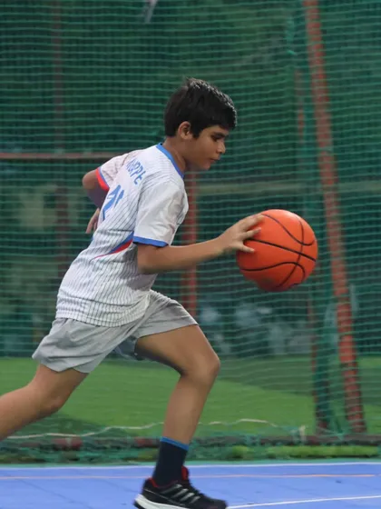 A young baller dribbles with focus. We train our players to be smart, tough, and ready to chase greatness.