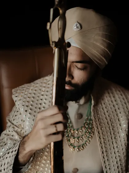 A close-up on the groom, capturing the details of his attire and the calm, regal presence he carries on his big day. A portrait of strength and elegance.