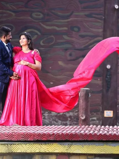 This bright pink maternity gown with a flowing trail is perfect for an outdoor shoot. The color is joyful and the style is comfortable, allowing you to move freely while looking fabulous.