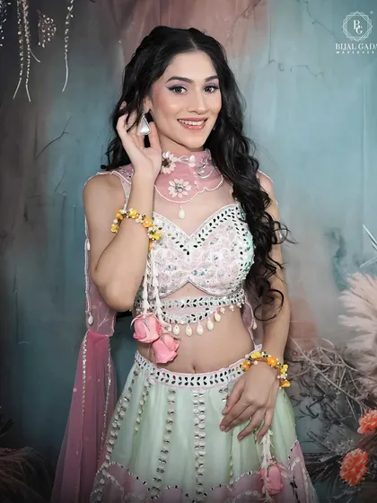 A happy and bright portrait of a model in a pastel lehenga. Her smile is infectious, and the makeup is kept fresh and light to match the playful vibe of the outfit.