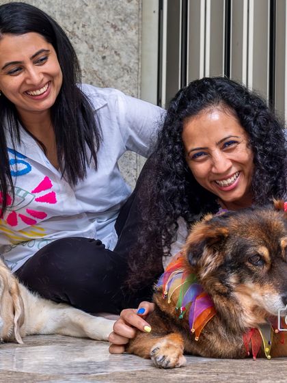 Two sisters sharing a happy moment with their two dogs, Scotch and Mocha. A perfect example of the sibling bonds, both human and canine.
