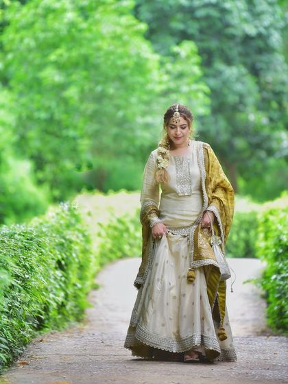 A candid walking shot on a park pathway. This captures the natural movement of the lehenga and gives a sense of effortless grace.